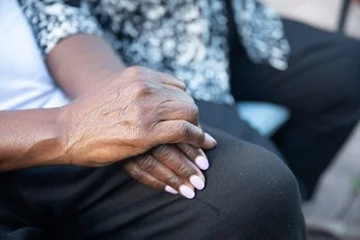 Two elderly black ladies holding hands